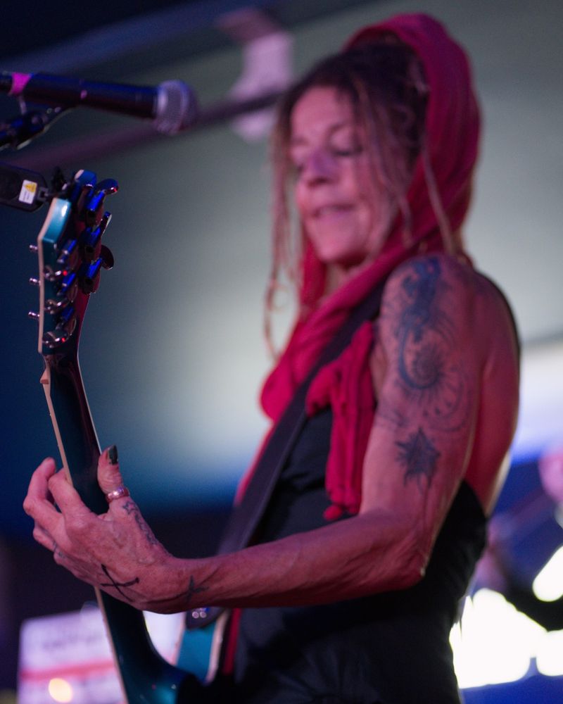 Marega Palser playing a teal guitar on stage